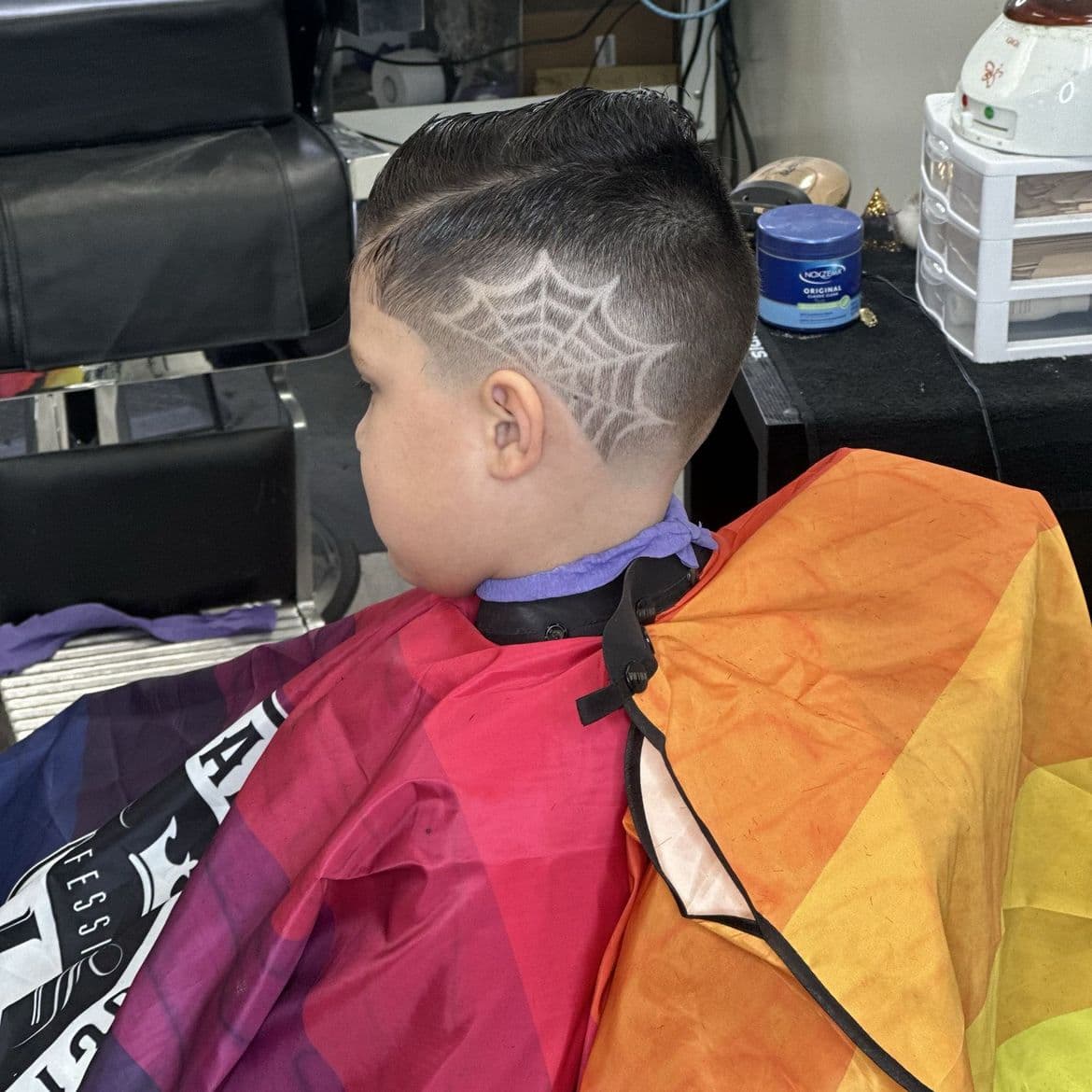 Kids haircut with a freehand razor spider web design on the side