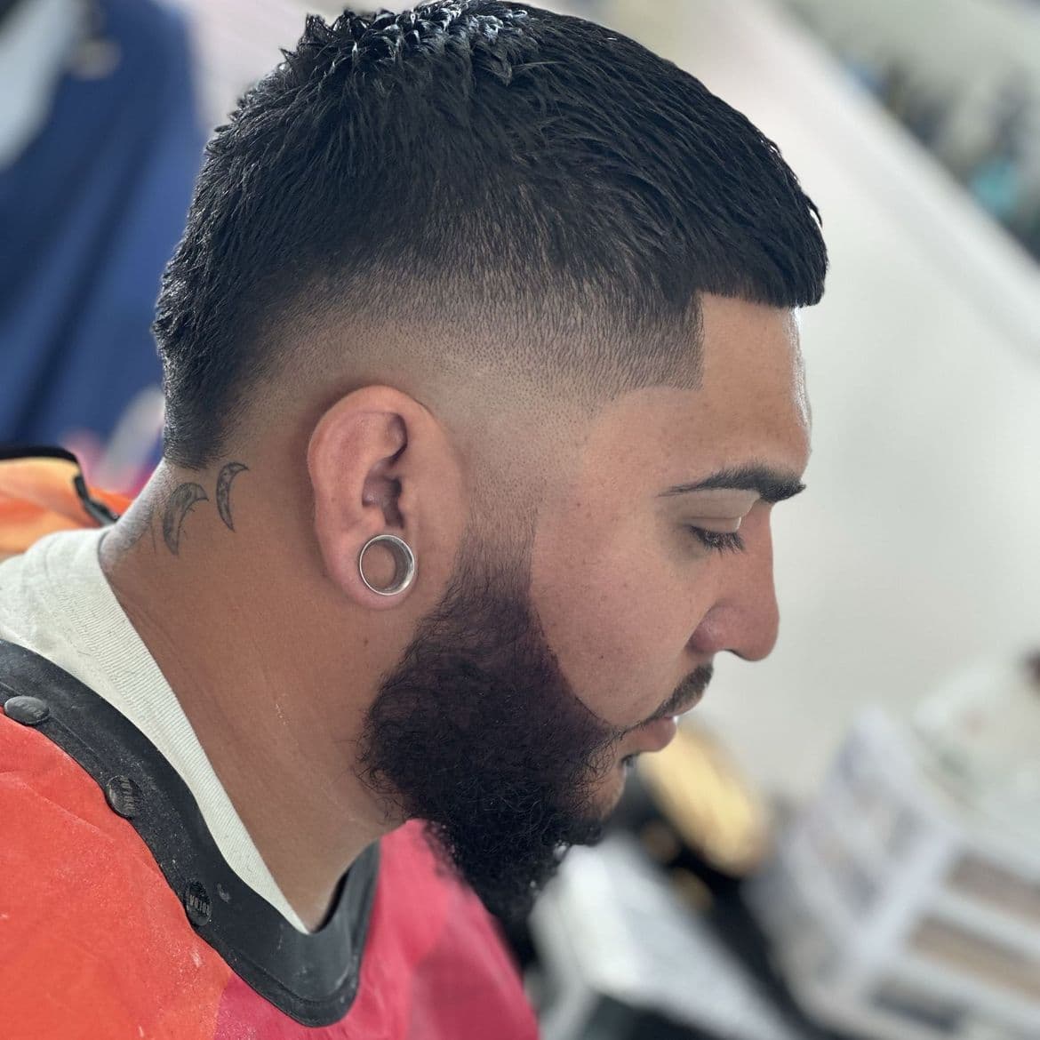 Mid fade with a crisp square hairline and a full shaped beard