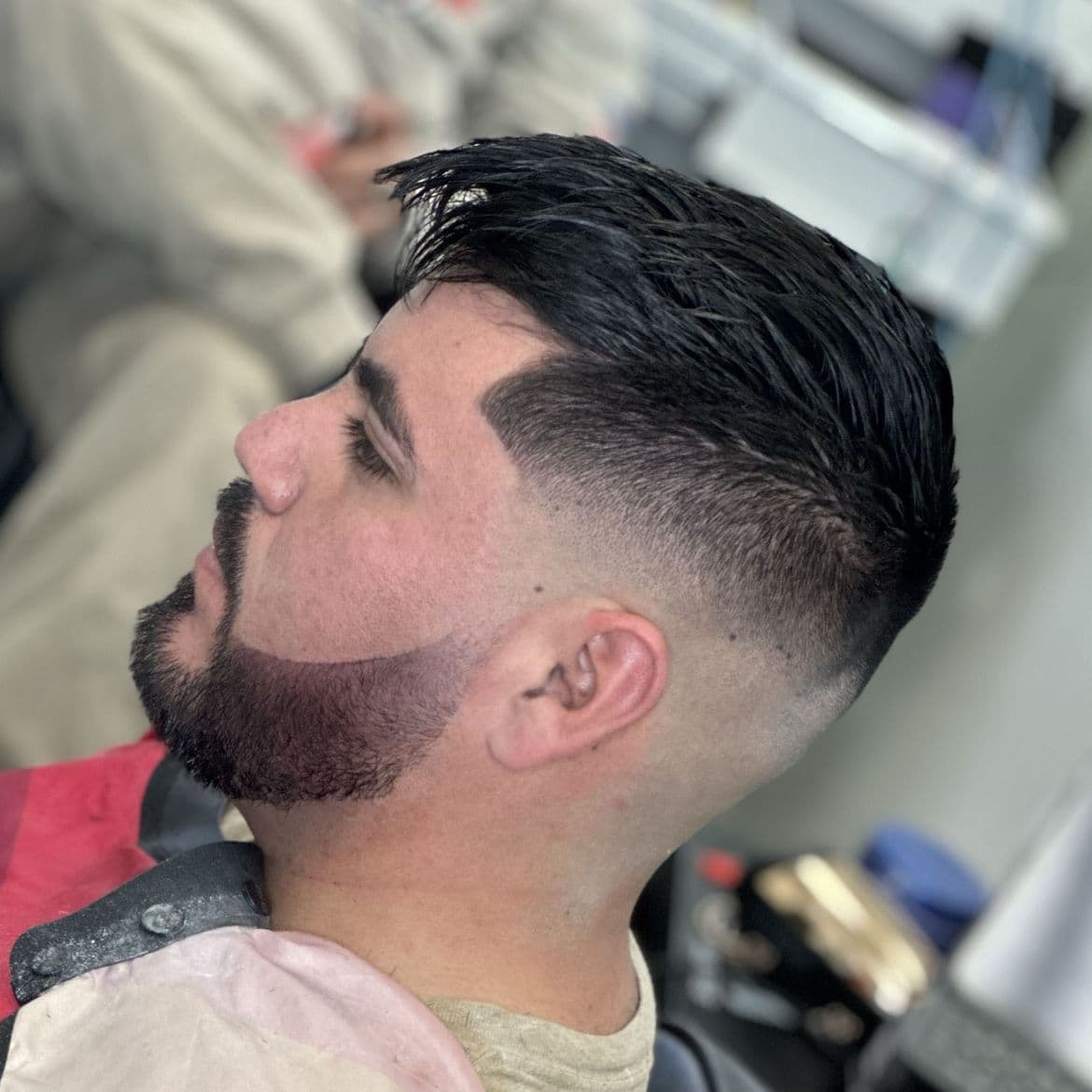 Mid taper fade with a textured top and a clean beard line at a Brighton CO barber shop